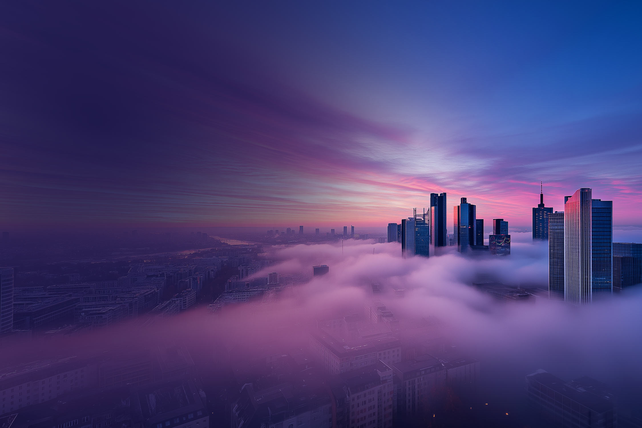 An impressive skyline of skyscrapers stretches through dense fog under a sky of violet and pink sunset tones.