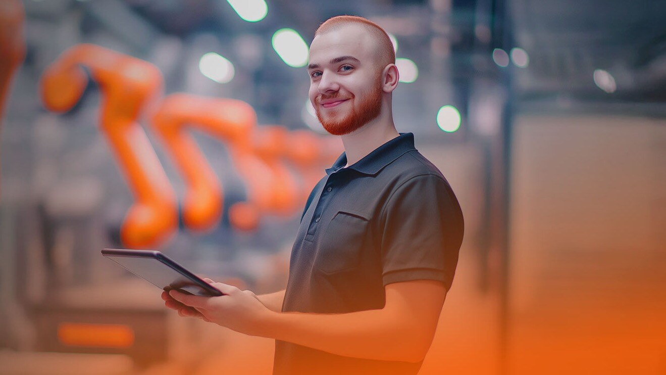 Man with tablet in front of KUKA industrial robots