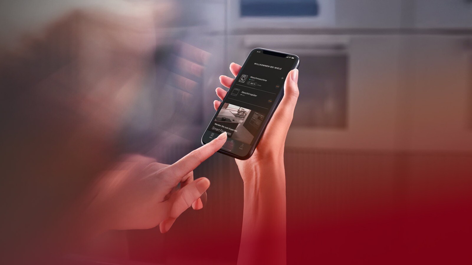 Person uses Miele app in modern kitchen.