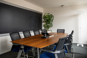 A meeting room with a wooden table and several chairs around it. 