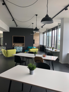 View from our bistro area with longer tables for several people. Also in the photo is our lounge area with large armchairs and TV ready for gaming.