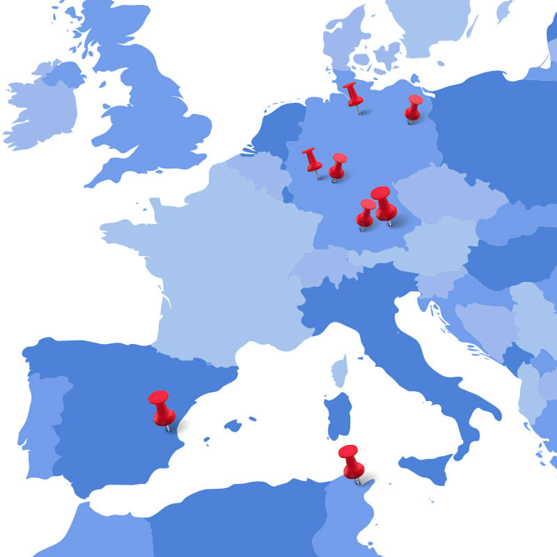 Ein graphischer, in Blau-Tönen gehaltener Weltkartenausschnitt, auf dem Deutschland, Spanien sowie Teile von Tunesien zu sehen sind. Rote Pinnadeln deuten an, wo unsere Standorte liegen.