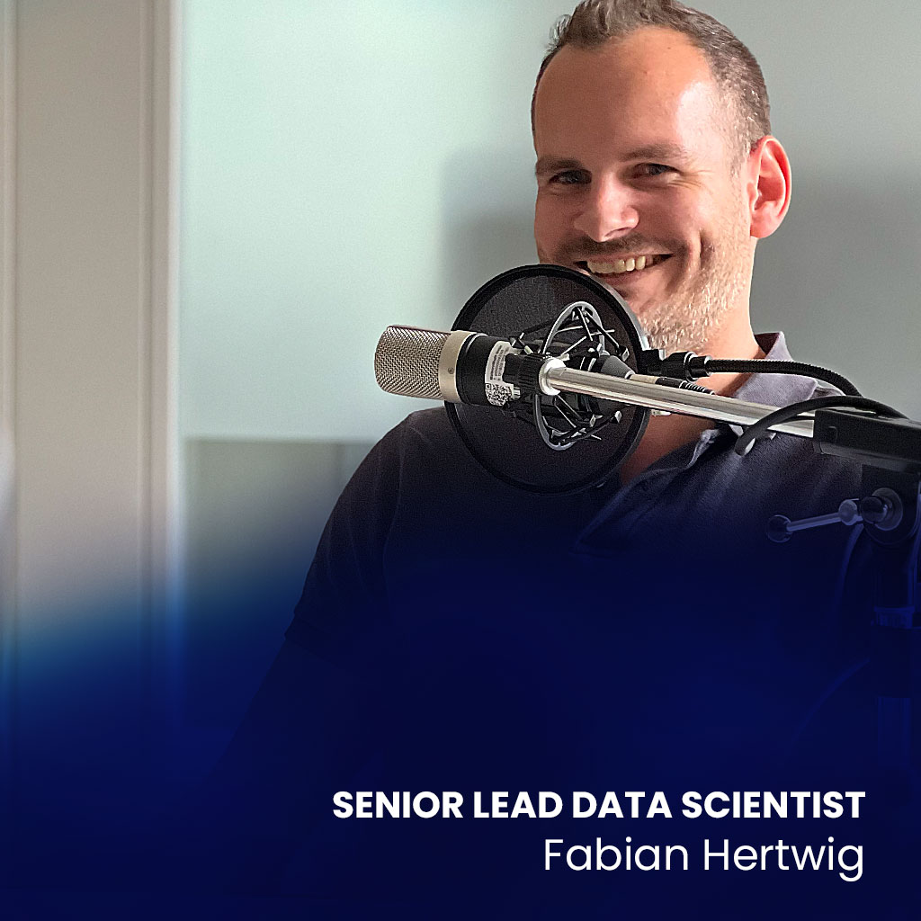Zu sehen ist Fabian Hertwig, Senior Lead Data Scientist von MaibornWolff, vor einem Mikrofon. Das Bild wurde bei der Aufnahme des Podcasts Heart-a-Tech aufgenommen.
